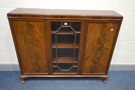 A MAHOGANY THREE DOOR BOOKCASE, with a central glazed compartment, enclosing adjustable shelves,