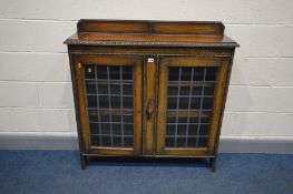 AN EARLY 20TH CENTURY OAK BOOKCASE, a raised back, lead glazed double doors enclosing two adjustable