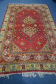 A WOOLLEN PERSIAN BAKSHAISH RUG, geometric motif within a red field, and a multi strap border, 297cm