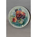 A MOORCROFT POTTERY SPRING FLOWERS PATTERN PLATE, on a blue/green ground, painted WM initials and