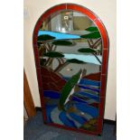 A DECORATIVE ARCHED MIRROR PANEL INSET WITH STAINED GLASS, forming an image of a Pike, a river and