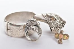 THREE SILVER GENTS RINGS AND A BANGLE, the first ring in the form of a textured eagles head, set