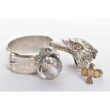 THREE SILVER GENTS RINGS AND A BANGLE, the first ring in the form of a textured eagles head, set