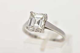 AN EMERALD CUT SINGLE STONE DIAMOND RING, the emerald cut diamond within a four claw setting to