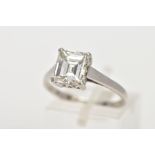 AN EMERALD CUT SINGLE STONE DIAMOND RING, the emerald cut diamond within a four claw setting to