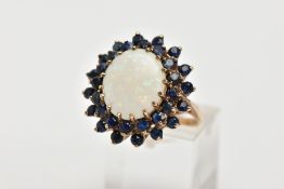 A LARGE 9CT GOLD OPAL AND SAPPHIRE RING centring on an oval cabochon white opal, measuring 14.2mm