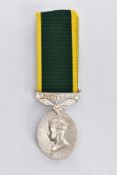 A GEORGE VI TERRITORIAL EFFICIENCY MEDAL, the oval medal suspended from a green and yellow ribbon,