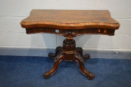 A VICTORIAN ROSEWOOD SERPENTINE CARD TABLE, the fold over top enclosing a brown velour inlay, on a