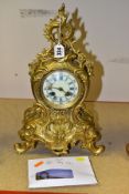 A LATE 19TH/EARLY 20TH CENTURY GILT METAL MANTEL CLOCK OF ROCOCO STYLE, scrolled finial with