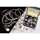 A SELECTION OF SILVER AND WHITE METAL JEWELLERY, to include various charms, two oval lockets, an