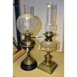 TWO OIL BURNING TABLE LAMPS, comprising of a single burner brass oil lamp standing on a black
