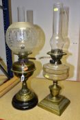 TWO OIL BURNING TABLE LAMPS, comprising of a single burner brass oil lamp standing on a black