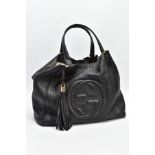 A BLACK GUCCI BAG, the soft leather with raised double G symbol to front centre, tassel attached