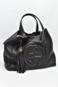 A BLACK GUCCI BAG, the soft leather with raised double G symbol to front centre, tassel attached