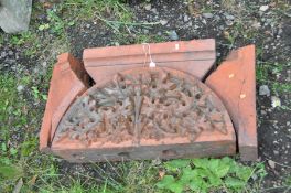 A LARGE TERRACOTTA ARCHECTURAL DOOR TOPPER with a central arch containing foliate and thistle detail