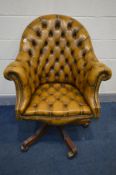A TAN LEATHER CHESTERFIELD DIRECTORS SWIVEL ARMCHAIR