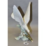 A LLADRO TURTLE DOVE, model no 4550, perched on leaves with wings raised, designed by Fulgencio