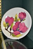 A MOORCROFT POTTERY PLATE, Magnolia pattern on cream ground, impressed marks to base and an adhesive