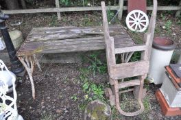 A GARDEN TABLE in need of restoration with a slatted wood top and cast iron ends width 123cm depth