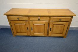 A MODERN SOLID GOLDEN OAK SIDEBOARD, three drawers above three cupboard doors, width 201cm x depth