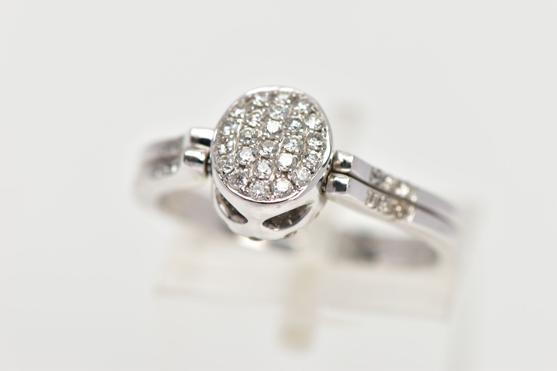 A DIAMOND SWIVEL RING, designed as an oval swivel panel, one side set with twenty-five brilliant cut