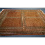 A WOLLEN RUSSET GROUND RUG, with a multi-strap border, 275cm x 365cm