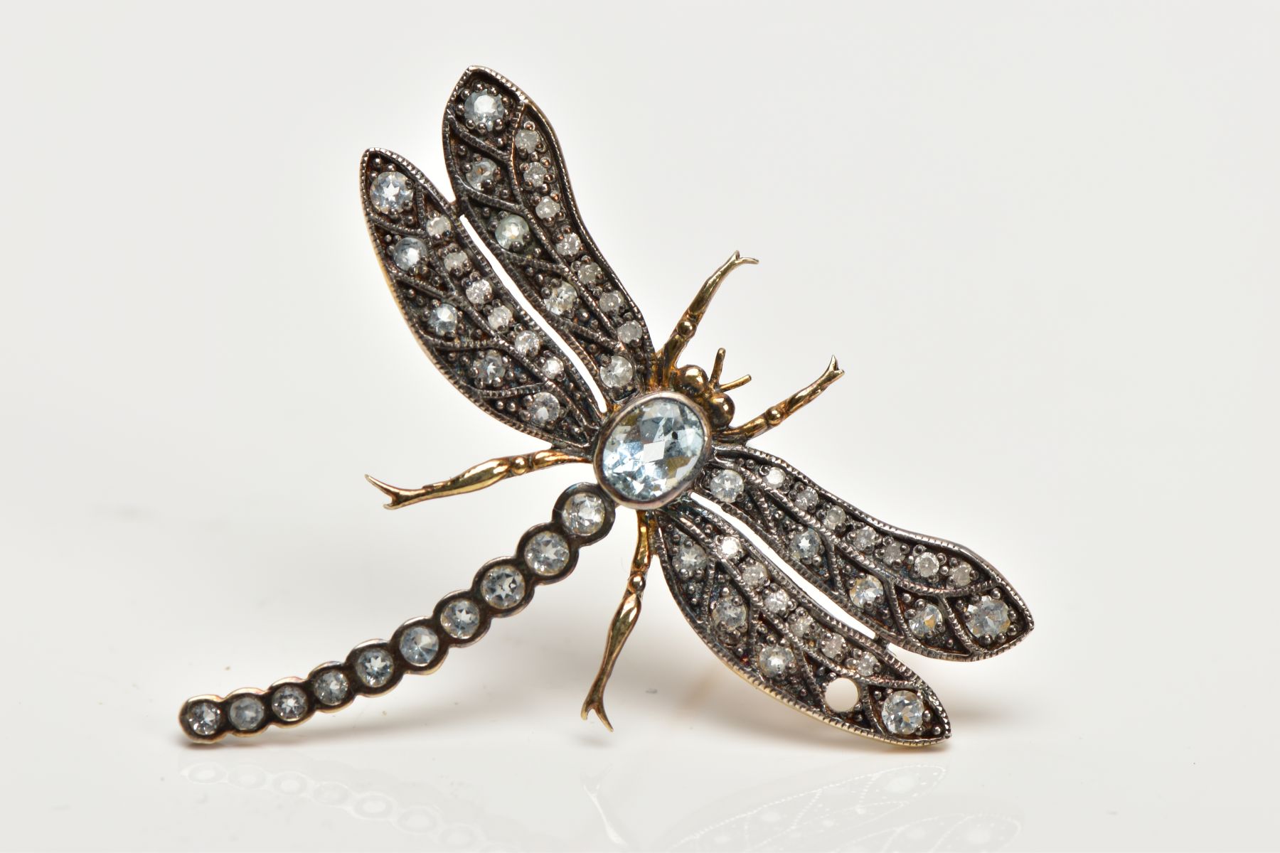 A DRAGONFLY GEM BROOCH, designed as a central oval blue topaz body and circular blue topaz tail, the