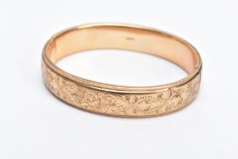 A 9CT GOLD OVAL HALF ENGRAVED OVAL HINGED BANGLE, half engraved with a floral and foliate fancy