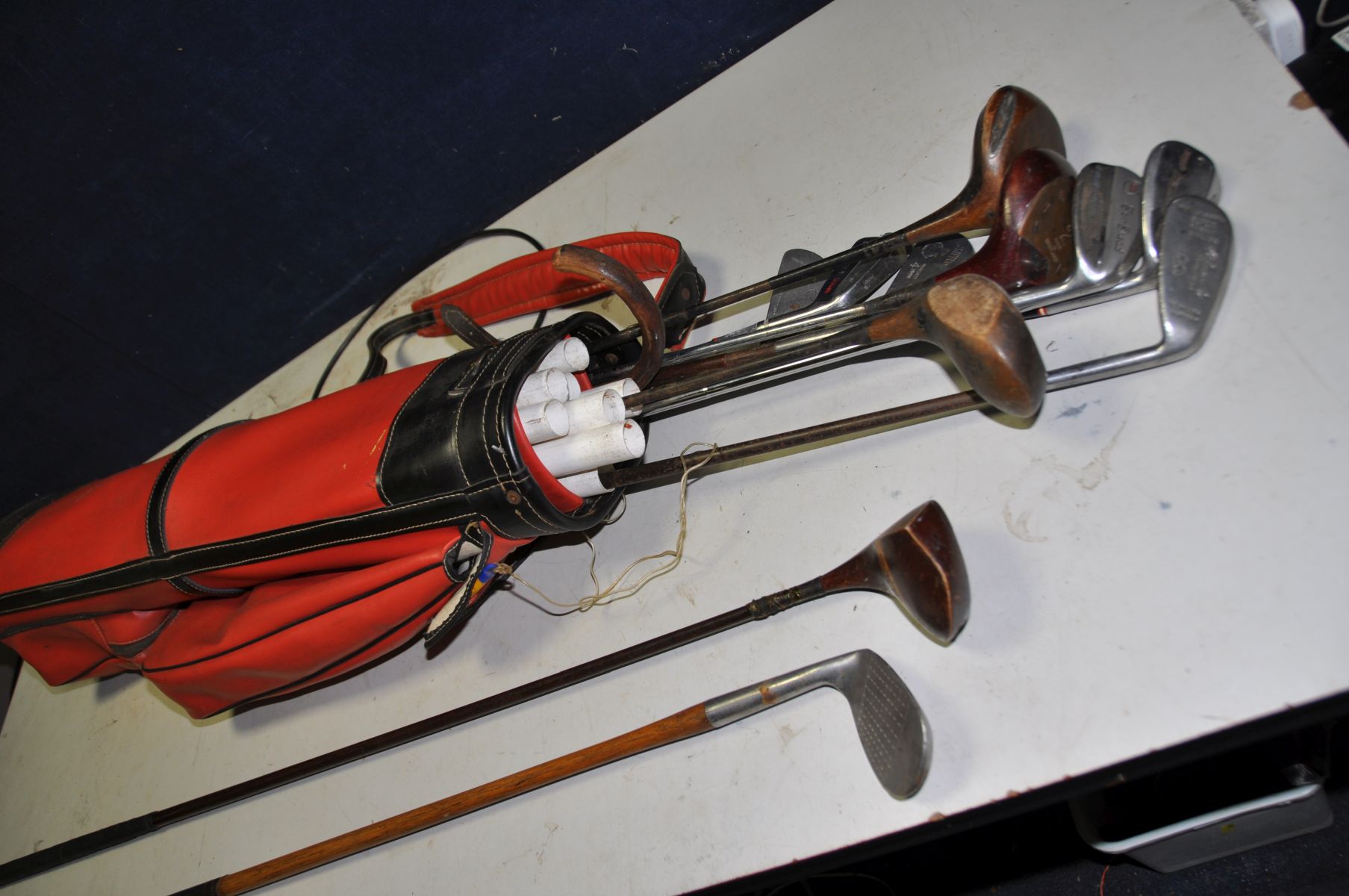 A VINTAGE GOLFBAG containing Wilson, Cochnamer, Leyland irons and A Burton, three other woods and