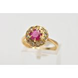 A YELLOW METAL RUBY AND DIAMOND CLUSTER RING, designed with a central claw set circular cut ruby,