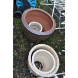 A LARGE TERRACOTTA PLANTER 52cm in diameter and a graduated nest of three glazed planters the