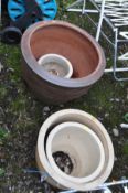 A LARGE TERRACOTTA PLANTER 52cm in diameter and a graduated nest of three glazed planters the