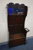 AN EARLY TO MID 20TH CENTURY OAK HALL STAND, with various hooks, bevelled mirror above a panelled