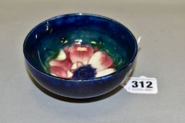 A MOORCROFT POTTERY FOOTED BOWL, decorated with an Anemone flower on a blue/green ground, bears