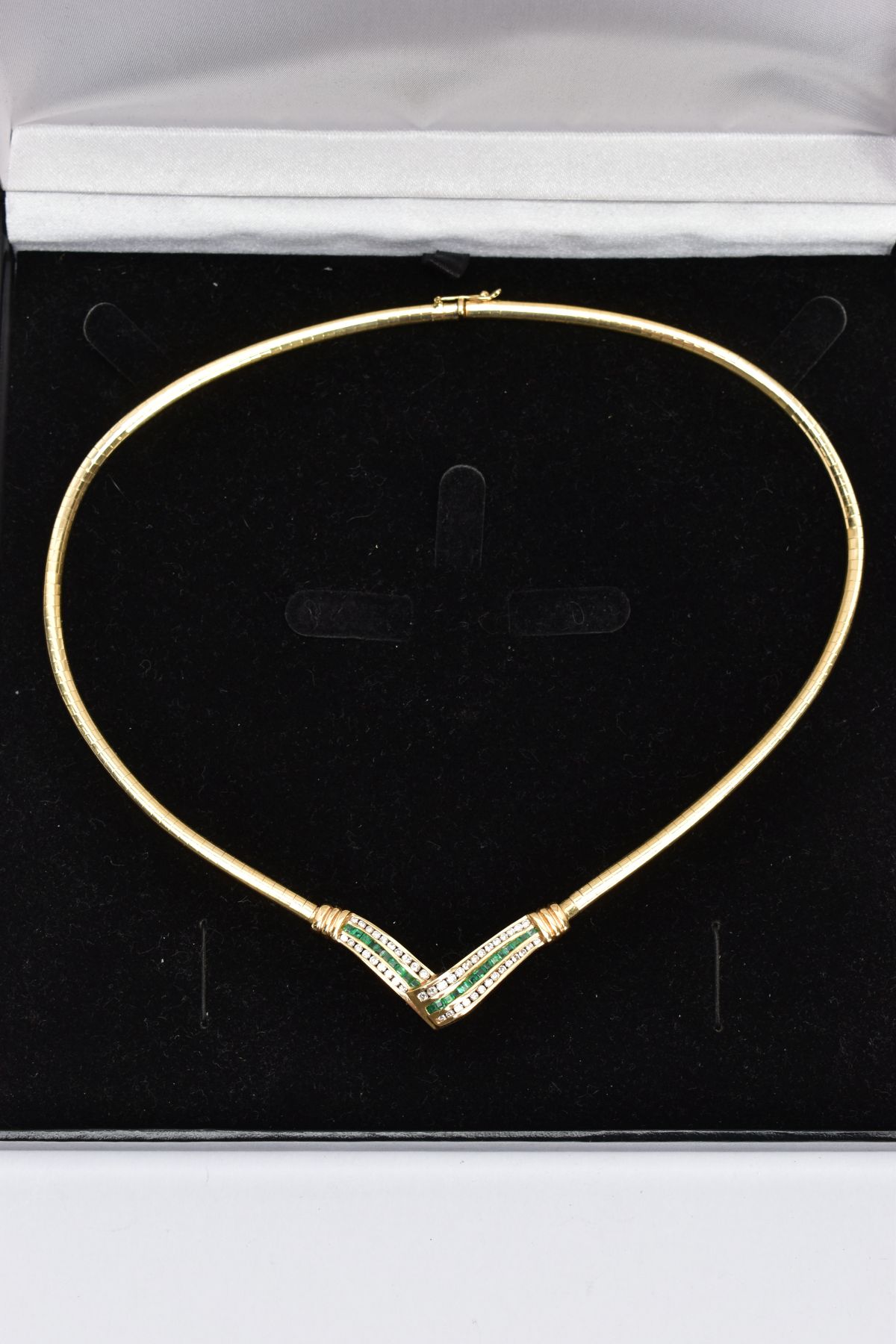 AN EMERALD AND DIAMOND COLLAR NECKLACE, the V-shape central panel channel set with a central line of