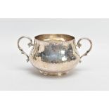 AN EARLY 20TH CENTURY SILVER DOUBLE HANDLED BOWL, the hammered bowl with two scrolling handles,