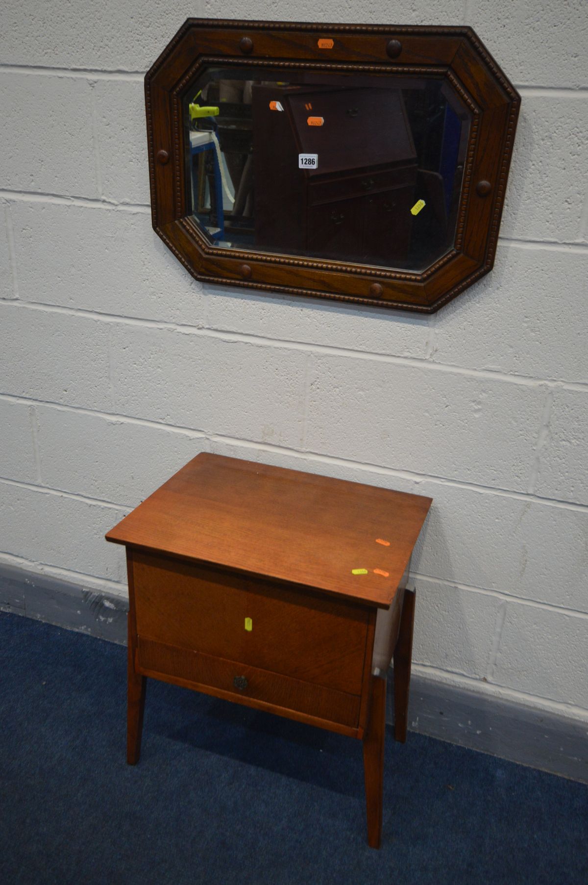 AN EARLY 20TH CENTURY OAK BEVELLED EDGE WALL MIRROR with canted corners, 64cm x 44cm and an oak