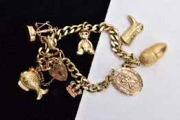A 9CT CHARM BRACELET, with eight charms and locket, approximate weight 26.8 grams