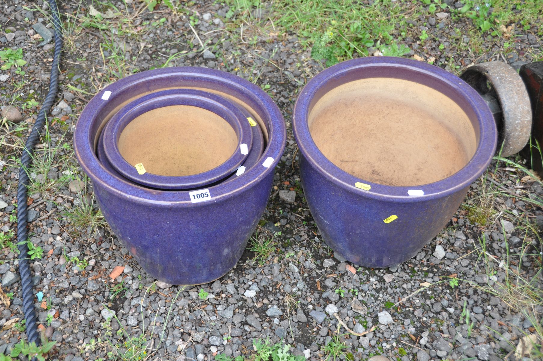 A SET OF FOUR PURPLE GLAZED PLANT POTS comprising of two at 37cm in diameter and two smaller (4)