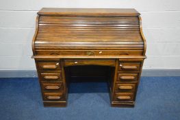AN EARLY 20TH CENTURY OAK TWIN PEDESTAL TAMBOUR ROLL TOP DESK, enclosing eleven pigeon holes and two