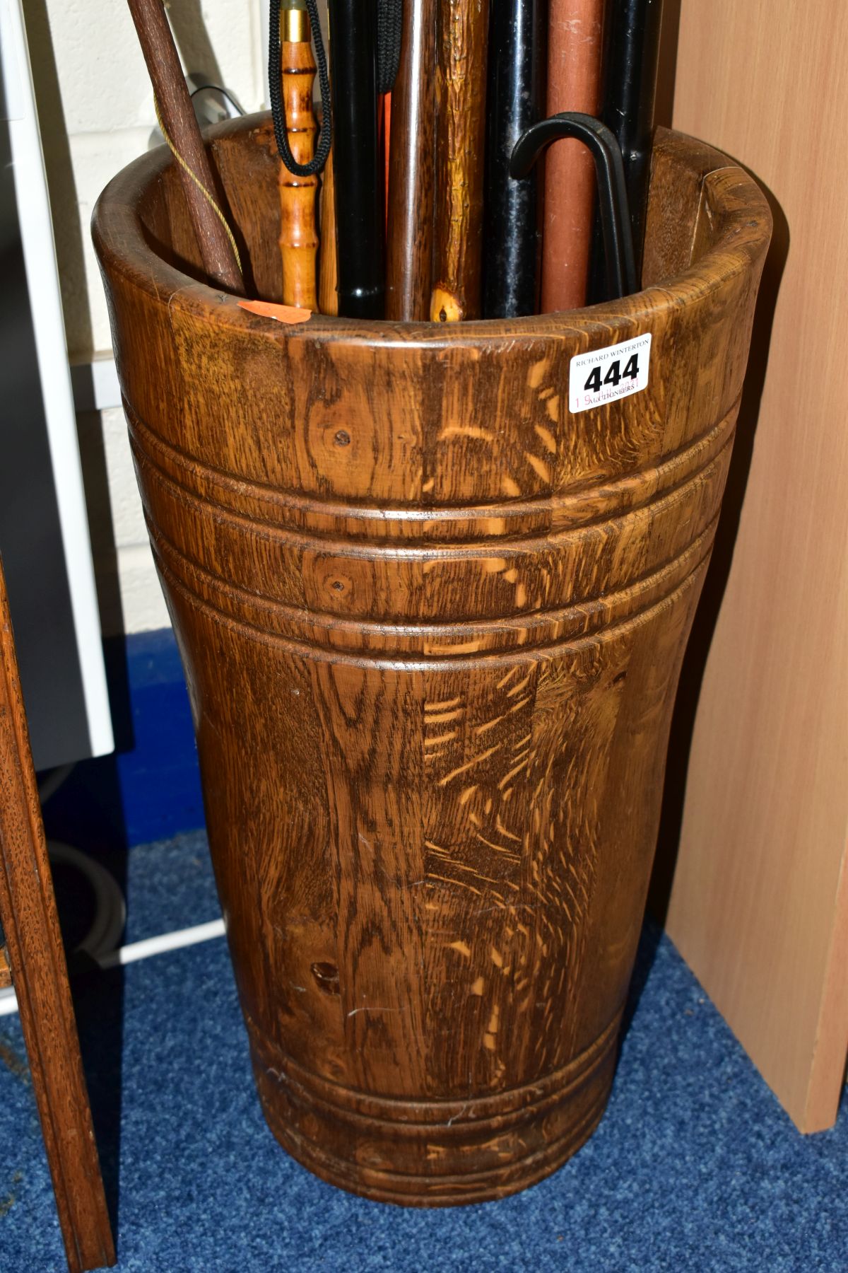 AN OAK STICK STAND OF PANELLED FORM, height 46cm, containing a back scratcher, a large wooden