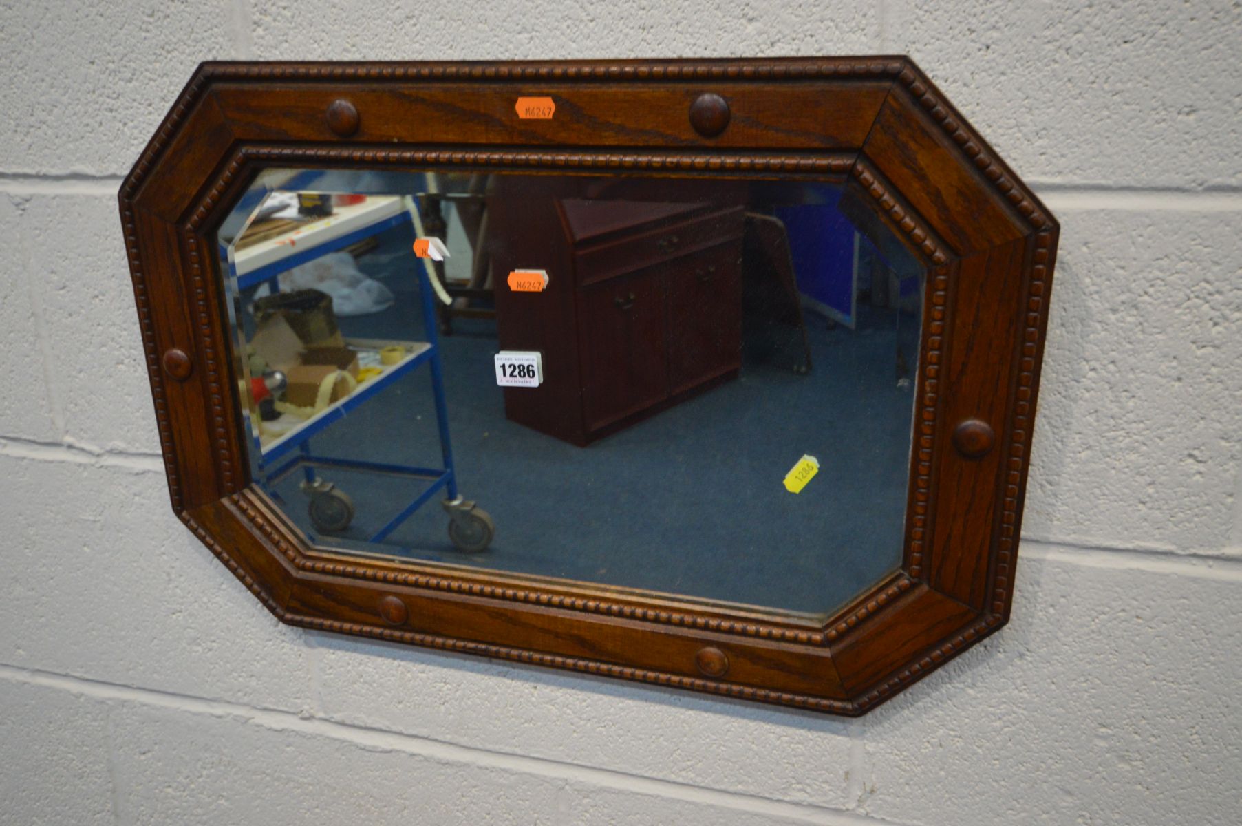 AN EARLY 20TH CENTURY OAK BEVELLED EDGE WALL MIRROR with canted corners, 64cm x 44cm and an oak - Image 2 of 3