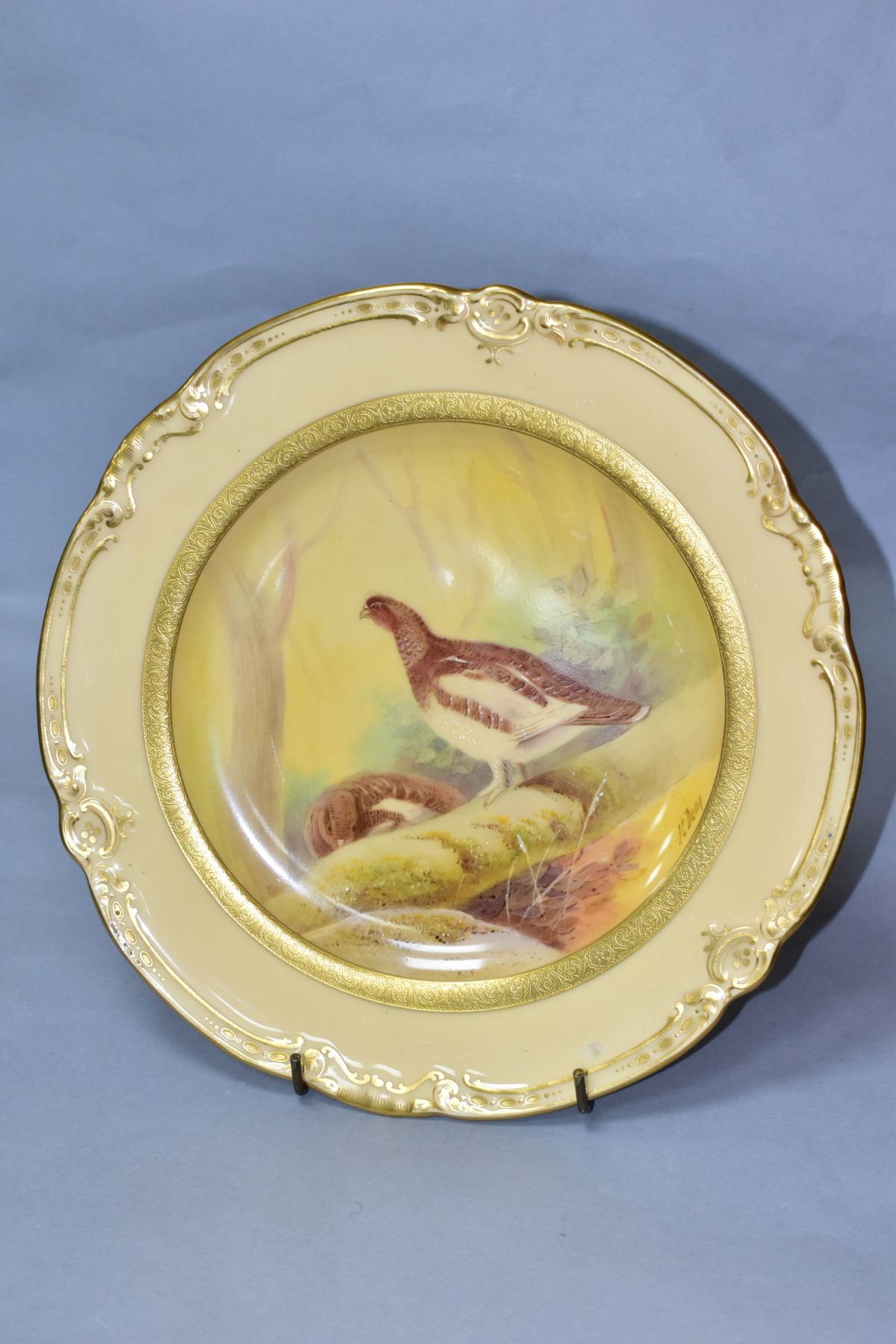 A MINTONS CABINET PLATE, painted by J E Dean 'ryper' (grouse in woodland) on cream ground with