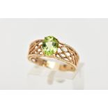 A 9CT GOLD PERIDOT RING, the oval peridot in a four claw setting to the tapered openwork rope