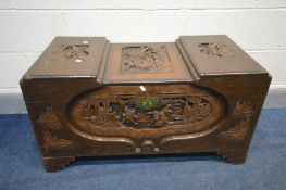 AN ORIENTAL HARDWOOD CAMPHORWOOD CHEST, surrounded with carved scenes throughout, on stepped feet,