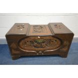 AN ORIENTAL HARDWOOD CAMPHORWOOD CHEST, surrounded with carved scenes throughout, on stepped feet,