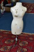 A TABLE TOP MANNEQUIN ON A WROUGHT IRON STAND, the fibreglass mannequin painted white, height 62cm