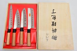 A SET OF FOUR JAPANESE KNIVES, each blade with engraved Japanese lettering and pierced holes, all