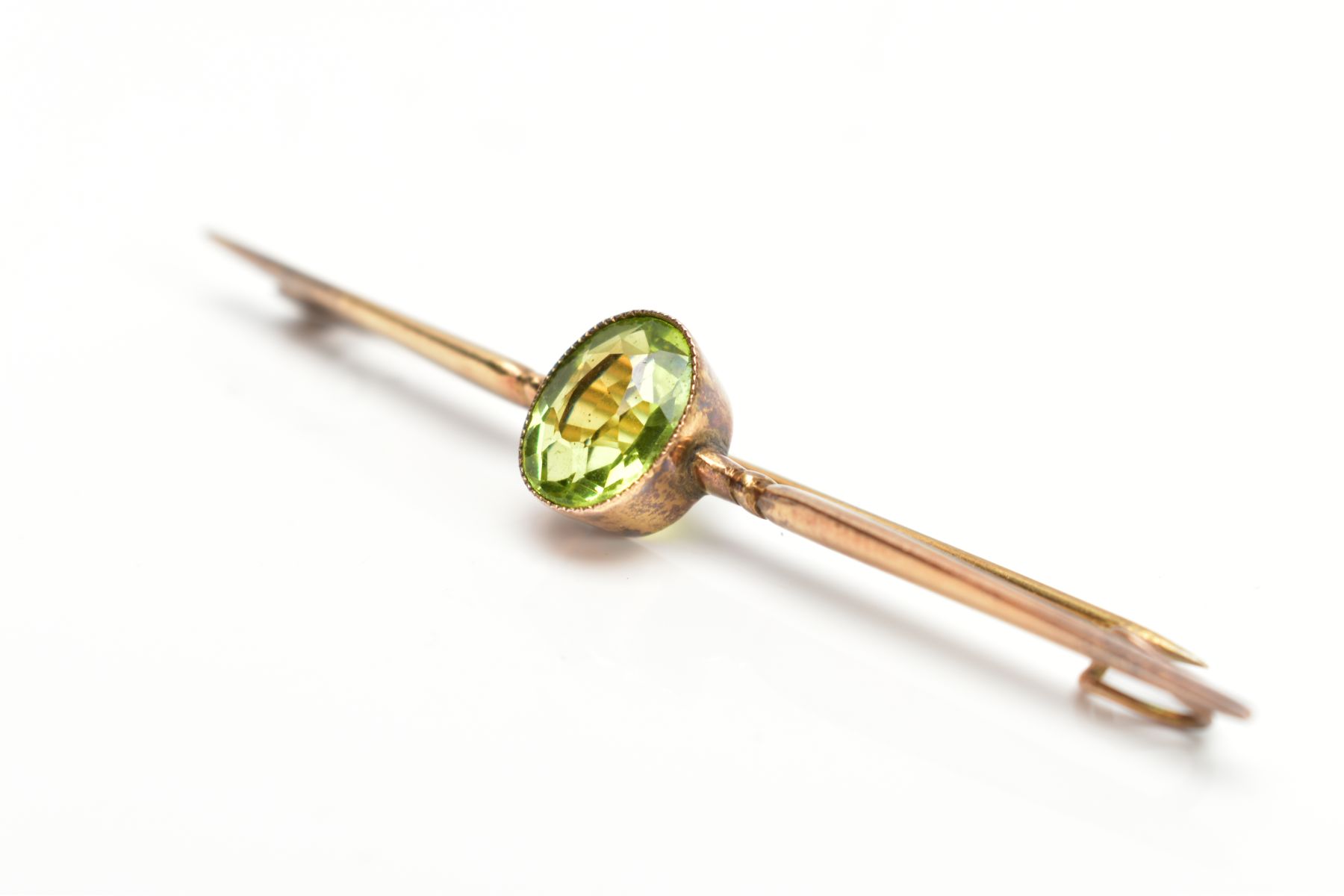 A PERIDOT BAR BROOCH, a single stone oval peridot miligrain set measuring approximately 10.0mm x 8. - Bild 3 aus 3