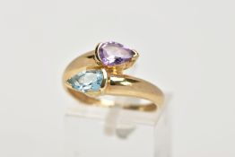 A 9CT GOLD AMETHYST AND TOPAZ CROSS OVER RING, designed as pear shape blue topaz and amethyst